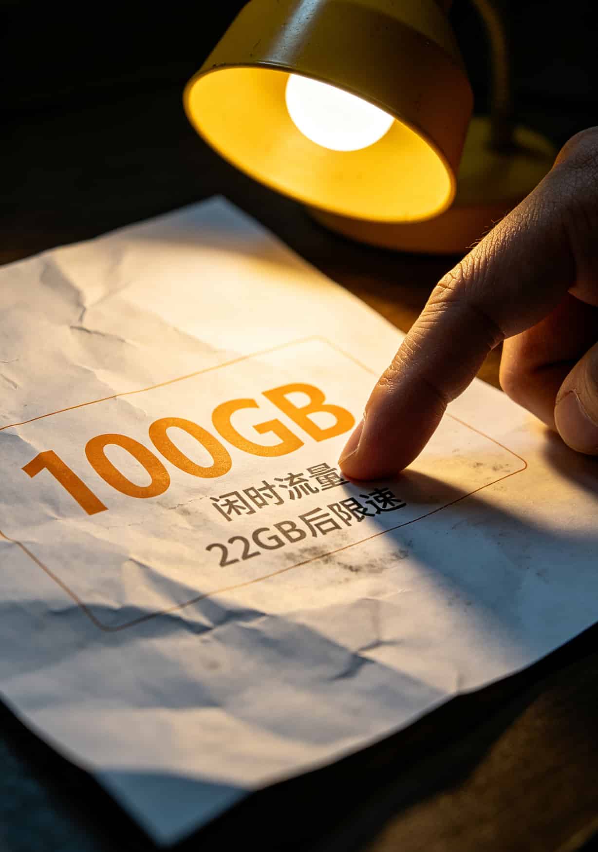 一张流量套餐宣传单的局部特写，上面写着100GB大流量，但小字部分模糊不清